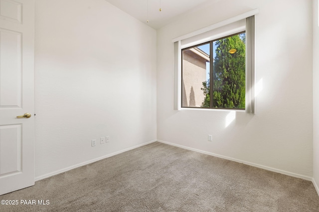 empty room featuring carpet and baseboards