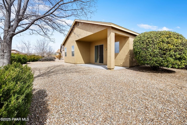 rear view of property with a patio area and stucco siding