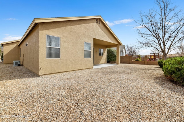 back of house with central air condition unit, fence, a patio, and stucco siding