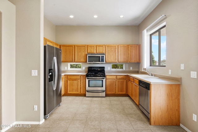 kitchen with light tile patterned floors, recessed lighting, stainless steel appliances, a sink, and light countertops