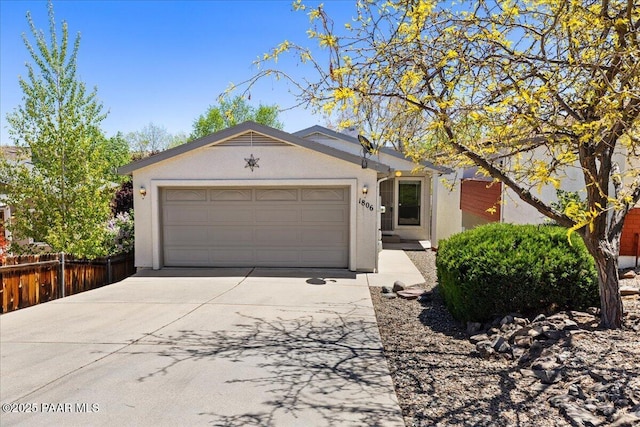 ranch-style house with driveway, fence, stucco siding, and an attached garage