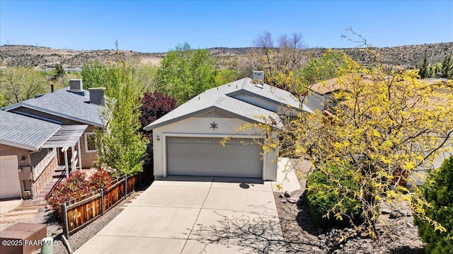 exterior space featuring stucco siding, concrete driveway, a mountain view, and a garage