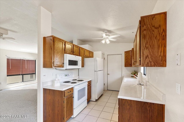 kitchen with a sink, light countertops, ceiling fan, and white appliances
