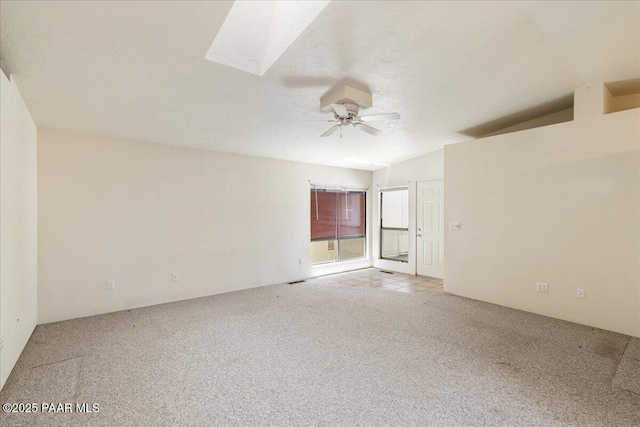 spare room featuring a ceiling fan, lofted ceiling, and light colored carpet