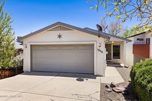ranch-style house featuring a garage, fence, stucco siding, and driveway
