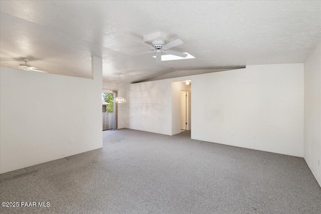 empty room with lofted ceiling, carpet, a ceiling fan, and a textured ceiling