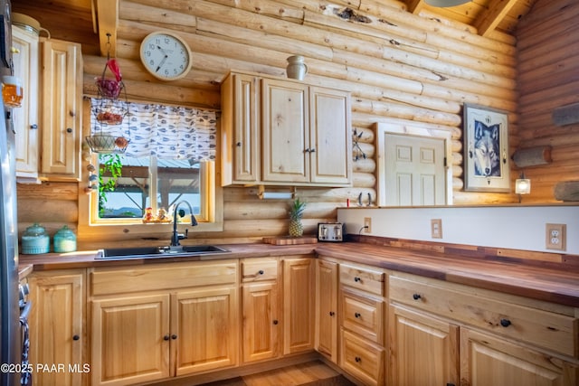 kitchen featuring light wood-type flooring, sink, and butcher block countertops