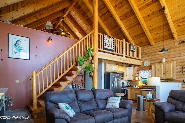 living room featuring beamed ceiling, high vaulted ceiling, rustic walls, and hardwood / wood-style floors