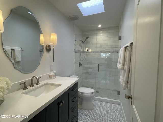 full bath with a shower stall, toilet, a skylight, tile patterned floors, and vanity