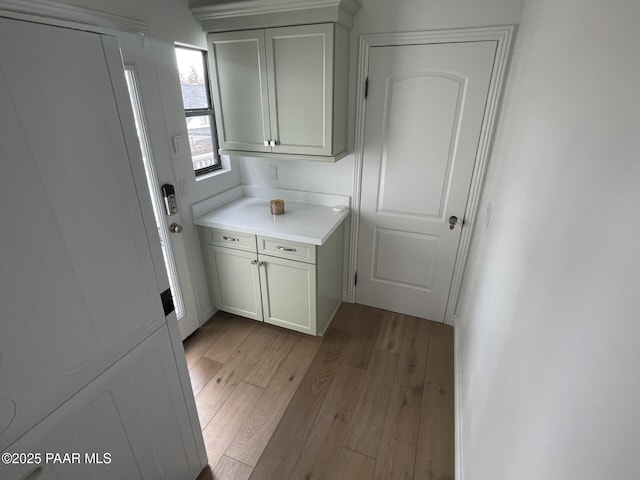 clothes washing area featuring light wood finished floors