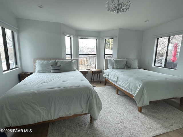 bedroom with multiple windows and wood finished floors