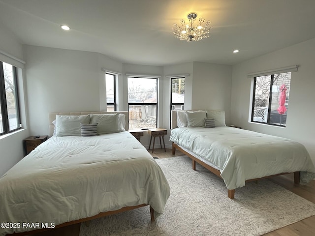 bedroom featuring recessed lighting, multiple windows, and wood finished floors