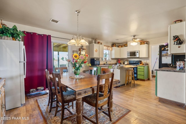 25820 N Poppy Dr, Paulden, AZ 86334 - dining space with light wood-style flooring, ceiling fan, and a chandelier