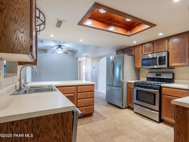 5700 N Concho Dr, Prescott Valley, AZ 86314 - kitchen featuring appliances with stainless steel finishes, a sink, arched walkways, a peninsula, and light countertops