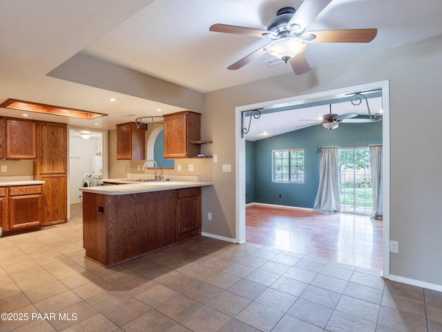 5700 N Concho Dr, Prescott Valley, AZ 86314 - kitchen featuring ceiling fan, a sink, brown cabinetry, a peninsula, and vaulted ceiling