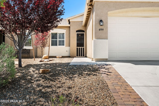 view of front of house featuring an attached garage, stucco siding, and driveway