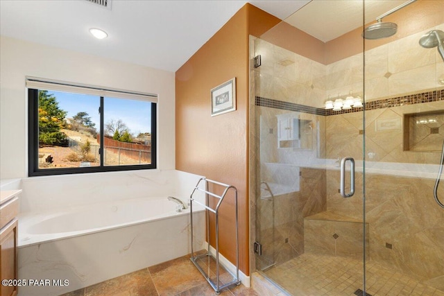 full bathroom featuring a stall shower, a garden tub, vanity, and baseboards