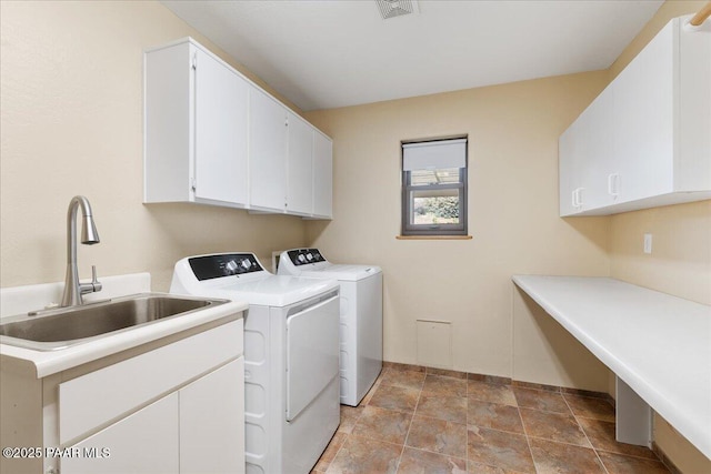 clothes washing area featuring cabinet space, washing machine and dryer, visible vents, and a sink