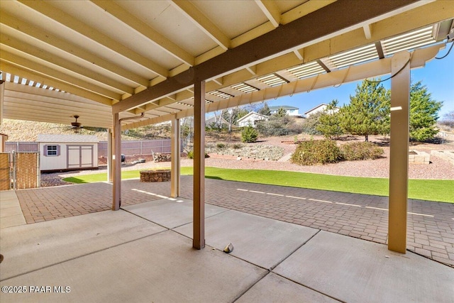 view of patio featuring an outbuilding, a storage shed, fence, and a pergola