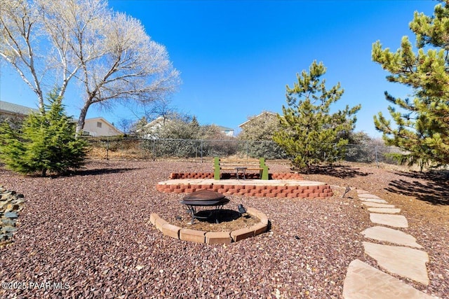 view of yard with an outdoor fire pit and fence