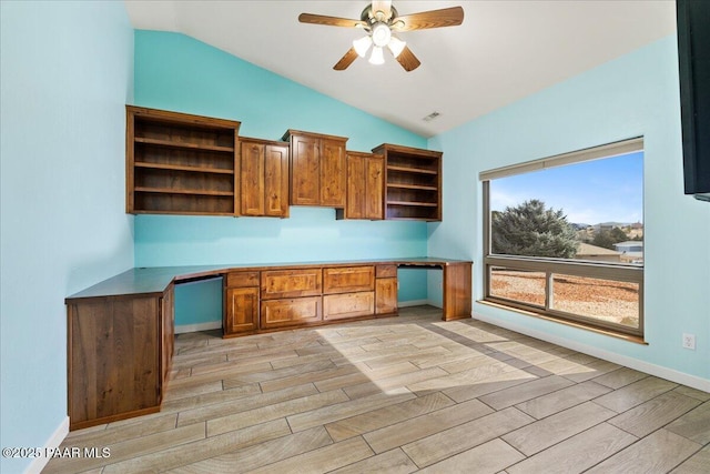 unfurnished office with lofted ceiling, wood tiled floor, and built in desk