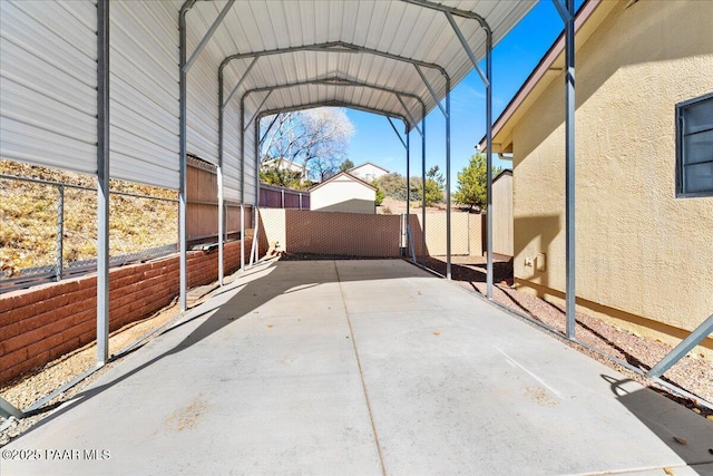 view of vehicle parking with fence and a detached carport