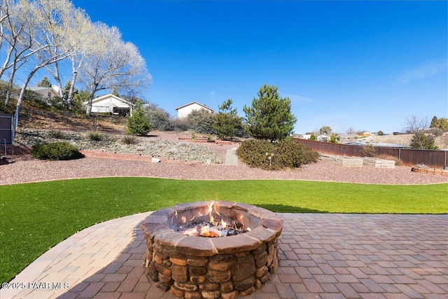 view of patio / terrace featuring fence and a fire pit