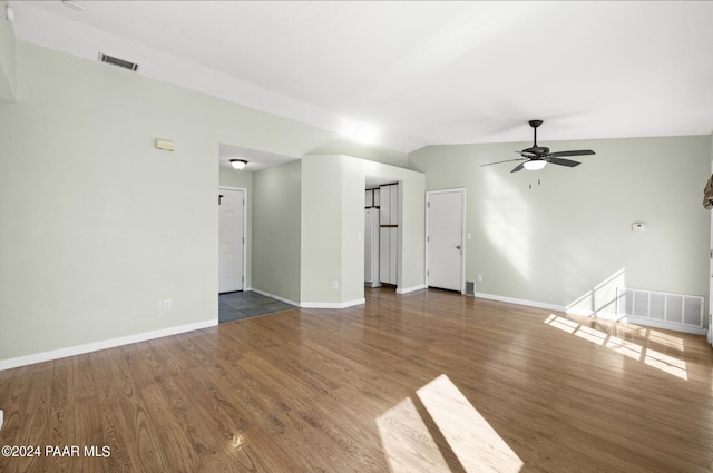 unfurnished living room featuring vaulted ceiling, ceiling fan, and dark wood-type flooring