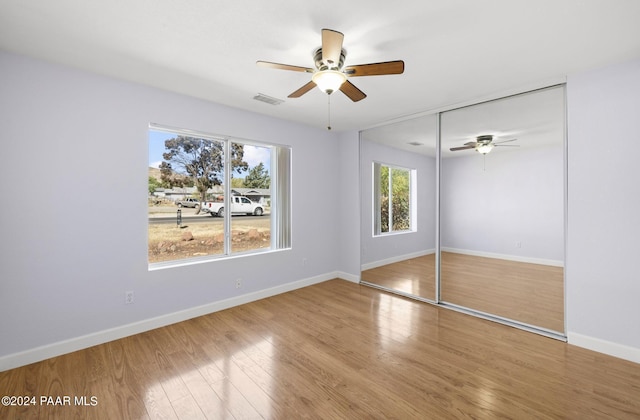 unfurnished bedroom featuring ceiling fan, a closet, and hardwood / wood-style floors