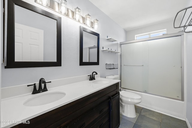 full bathroom with tile patterned flooring, vanity, toilet, and bath / shower combo with glass door