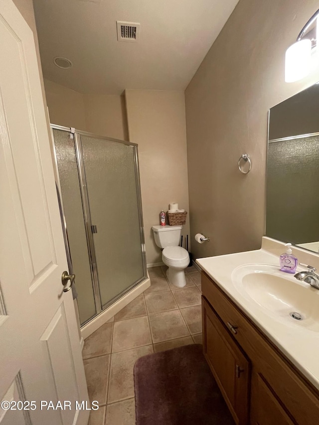 full bathroom featuring a shower stall, vanity, tile patterned floors, toilet, and visible vents