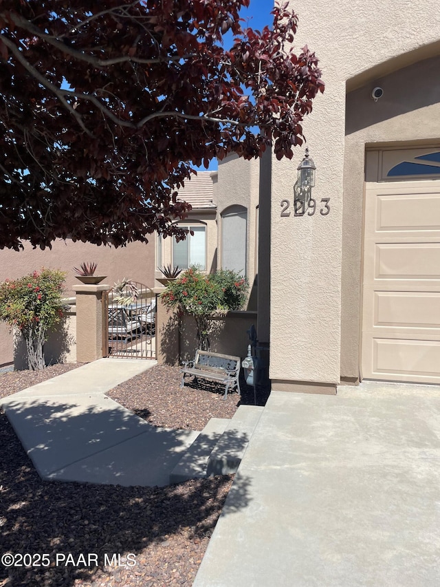 exterior space featuring a gate and stucco siding