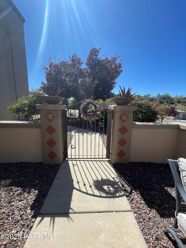 view of gate with a fenced front yard