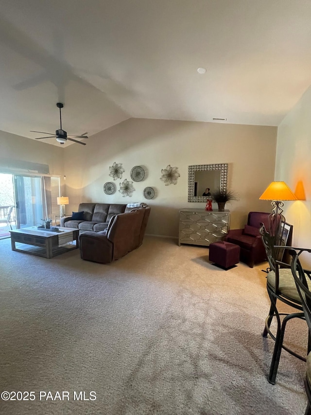 living area featuring a ceiling fan, vaulted ceiling, and carpet floors