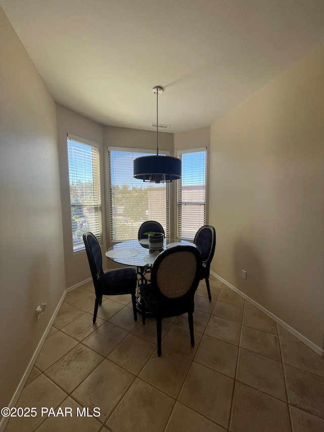 dining space featuring light tile patterned floors and baseboards