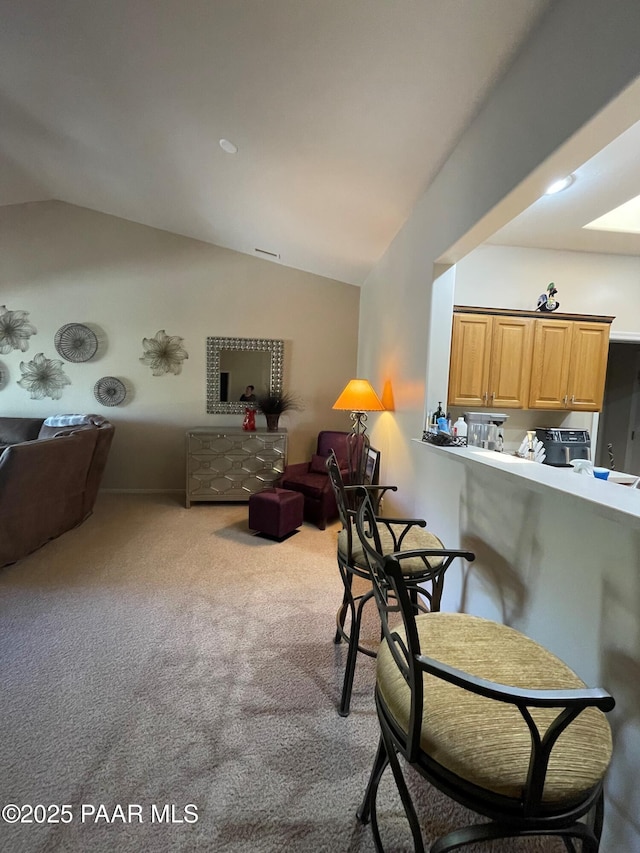 carpeted living area featuring vaulted ceiling