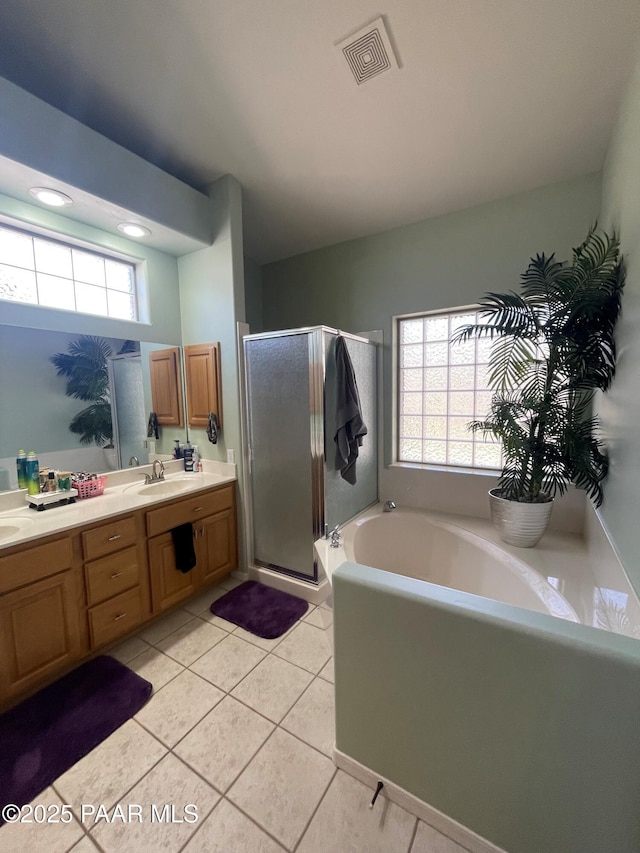 full bath featuring a shower stall, double vanity, visible vents, a bath, and tile patterned floors