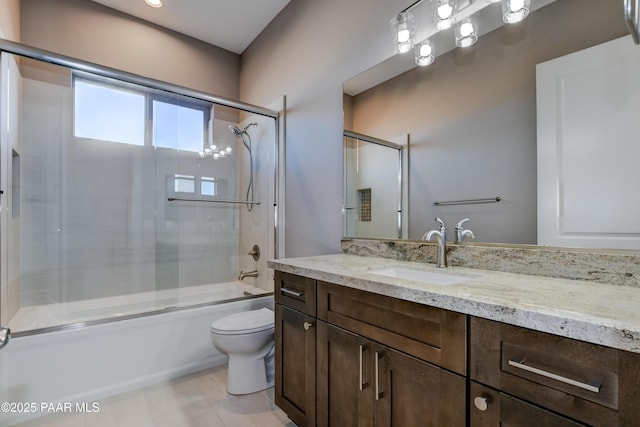 full bathroom featuring vanity, toilet, and shower / bath combination with glass door