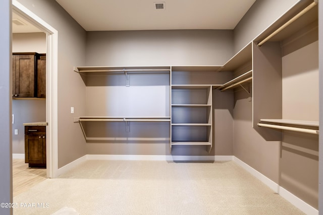 walk in closet with visible vents and carpet floors