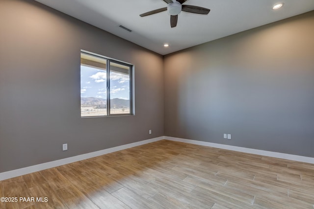 unfurnished room with visible vents, light wood-style flooring, baseboards, and ceiling fan