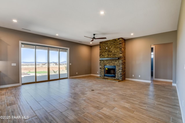 unfurnished living room with baseboards, recessed lighting, a fireplace, light wood-style floors, and a ceiling fan