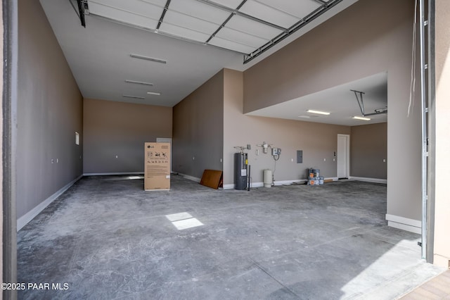 garage featuring baseboards and water heater