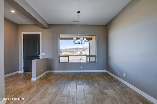 unfurnished dining area with visible vents, baseboards, an inviting chandelier, and wood finished floors