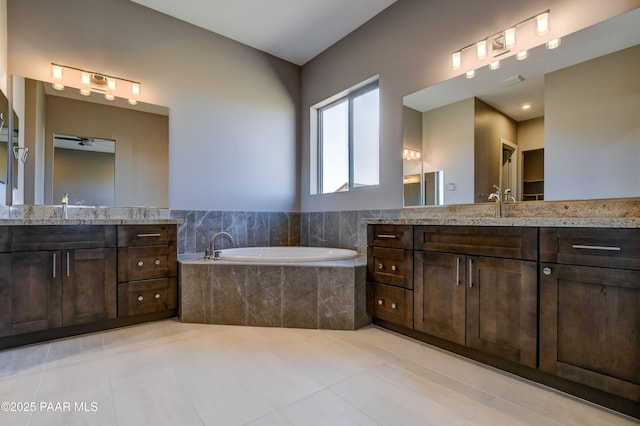 bathroom featuring tile patterned flooring, a garden tub, and two vanities