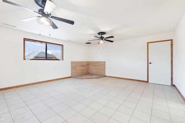 tiled spare room featuring ceiling fan