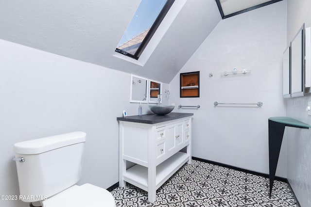 bathroom featuring vanity, toilet, and lofted ceiling with skylight