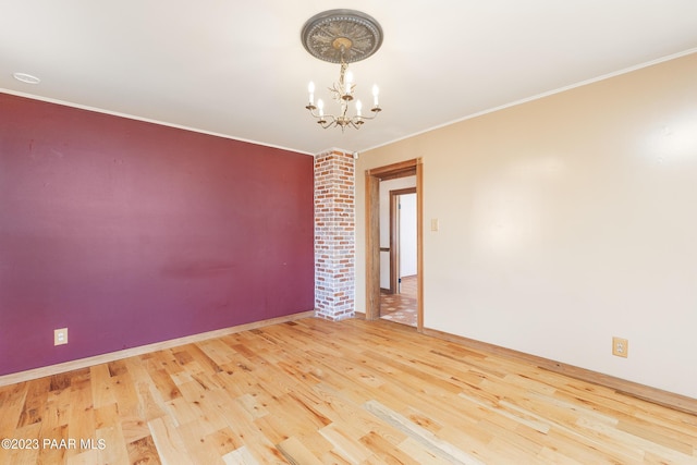 spare room with crown molding, a chandelier, and hardwood / wood-style flooring