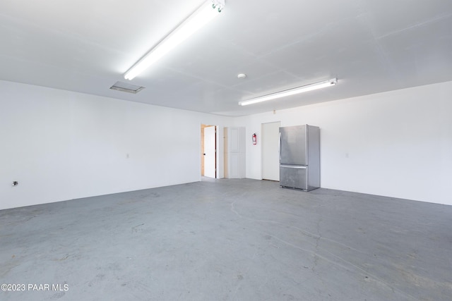 garage with stainless steel refrigerator