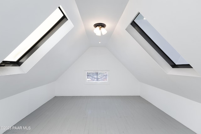 bonus room with light hardwood / wood-style flooring and vaulted ceiling