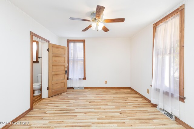 unfurnished bedroom with light wood-type flooring, ensuite bathroom, ceiling fan, and ornamental molding